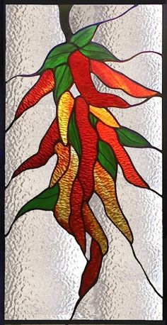 a stained glass window with red and yellow peppers hanging from it's center piece