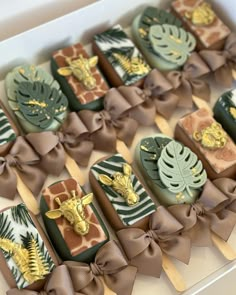 the chocolates are decorated with giraffes and palm leaves on them, as well as brown bows