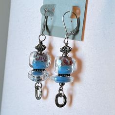 a pair of earrings hanging from hooks on a wall