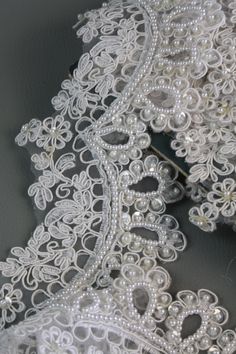 white lace with pearls and beads on it