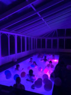 people are in an indoor swimming pool at night