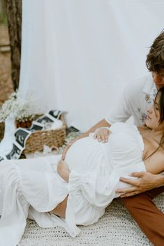 a man and woman are cuddling on the ground