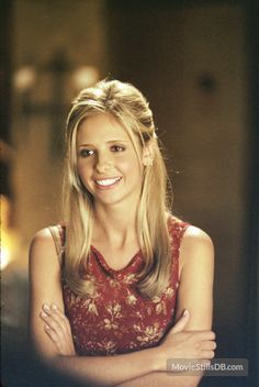 a woman with her arms crossed smiling