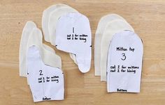 three pieces of white paper taped to each other on a wooden surface with instructions for how to fold them