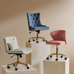 two office chairs sitting on top of white pedestals in front of a beige wall