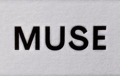 the word museum written in black on a white wall