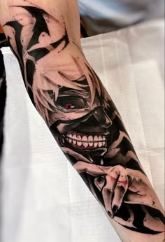 a man's arm with a black and white tattoo design on it, including a skull