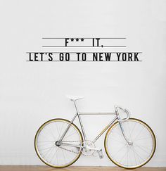 a black and white photo of a bicycle against a wall that says it lets go to new york