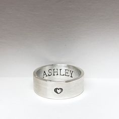 This 6mm wide sterling silver band is handmade and customized with a phrase, symbol, name of your choice stamped on the inside and/or the outside. Up to 20 characters (including spaces, symbols, and punctuation marks) can fit on the outside as well as on the inside. This band is band with sterling silver, making it a durable and long-lasting tribute to your loved one. Silver Hand Stamped Promise Ring, Promise Stackable Rings Hand Stamped In Sterling Silver, Promise Sterling Silver Hand Stamped Stackable Rings, Promise Stackable Rings In Sterling Silver Hand Stamped, Promise Stackable Hand Stamped Sterling Silver Rings, Silver Hand-stamped Engraved Ring, Hand Stamped Sterling Silver Engraved Ring, Hand Stamped Sterling Silver Engraved Ring As Gift, Sterling Silver Engraved Promise Ring With Thick Band