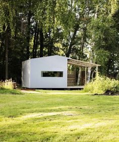 an image of a small house in the middle of a field with trees and grass