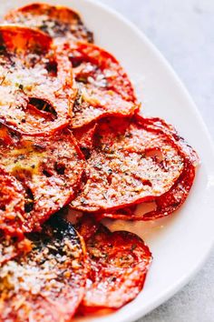 sliced tomatoes on a white plate with parmesan cheese