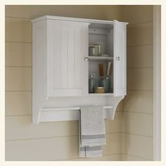 a white cabinet with towels hanging from it's sides