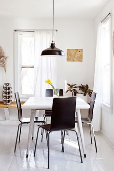 a dining room table and chairs with white walls