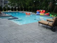 an empty swimming pool with lounge chairs and inflatable floats