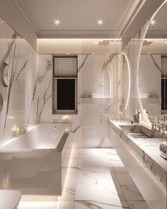 an elegant bathroom with marble walls and flooring, lighted by lights on the ceiling