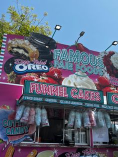 an ice cream stand with lots of desserts on it's sides and signs