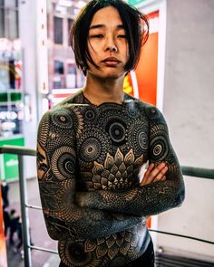 a man with tattoos on his chest and arms