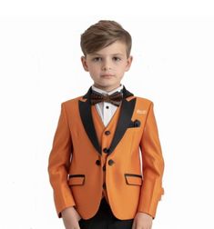 a young boy dressed in an orange tuxedo and bow tie with black pants