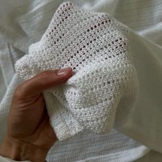 a hand holding a white crocheted cloth