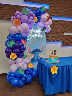 a balloon arch with an image of stitch and lillies on it at a birthday party