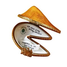 an ornament shaped like a hat with writing on the bottom and gold trim