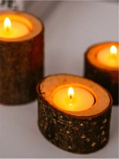 three lit candles sitting on top of a table