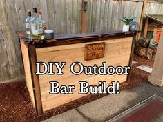 an outdoor bar built into the side of a wooden fence with bottles on it and text overlay that reads diy outdoor bar build