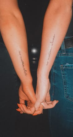 two people holding hands with tattoos on their arms and the words love are written in cursive writing