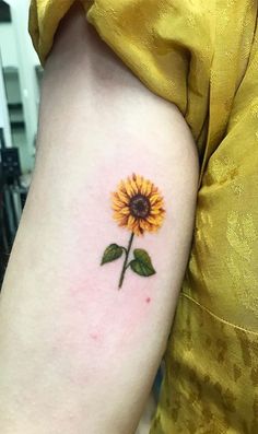 a small sunflower tattoo on the arm