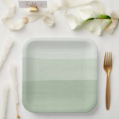 a place setting with white flowers and gold cutlery