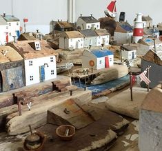 a bunch of wooden houses sitting on top of a table next to flags and other items