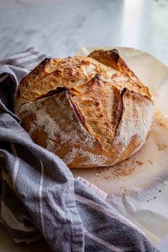 a loaf of bread sitting on top of a white plate next to a gray towel