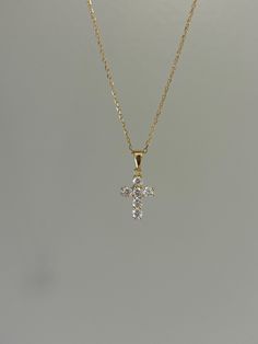 Dainty and so sparkly, this cross necklace is a must-have! You will shine at every step that you take. Information: ✨ Sterling Silver (925 stamped) | 14K Gold Plated ✨ AAA grade Cubic Zirconia gemstones ✨ Adjustable length: 16" - 18" ✨ Hypoallergenic ✨ Tarnish resistant ✨ Water friendly Our cross necklace has an splendid level of craftsmanship and attention to detail, from the carefully set gemstones to the high polishing of the metal. Once you see the necklace, there is no doubt about the quality. Plus, the necklace is adjustable. You have the ability to wear it at 16", 17" or 18" allowing you to create various layering possibilities and find your best fit. For centuries, Christians have seen the cross as a symbol of their faith and divine protection. It makes a great talisman and gives y Cross Necklace Dainty, Elegant Cross Necklace For Confirmation, White Cross Pendant Necklace For Baptism, White Cross Necklace For Baptism, White Cross Necklace For First Communion, Cross Gold Necklace, Cross Necklace Gold, Diamond Cross Necklace Gold, Dainty Cross Necklace