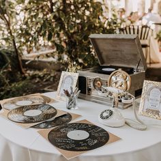 an old fashioned record player sitting on top of a table next to two other records