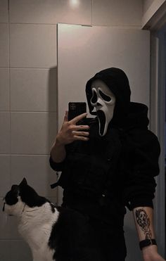 a person in a mask taking a selfie with a cat