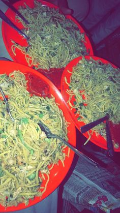 three plates filled with noodles and vegetables on top of a table next to each other