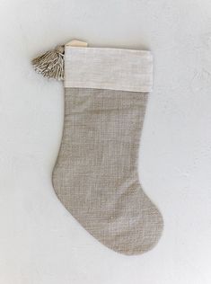 a christmas stocking with a tassel hanging from it's side on a white wall