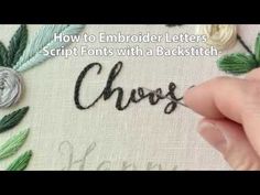 someone is stitching the word choose on a piece of fabric with flowers and leaves