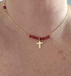 Elevate your style with our handmade 14k gold-filled cross necklace, featuring a stunning combination of faceted and smooth garnet beads along with clear crystal beads. This minimalist and dainty cross necklace offers both beauty and spiritual significance, perfect for any occasion. The anti-tarnish 14k gold-filled chain ensures durability and a lasting shine, while the delicate cross charm adds a touch of faith and elegance. *Free Shipping excludes Hawaii, Alaska and International.  Materials: Dainty Cross Necklace, Choker Gold, Mini Cross, Pendant Choker, Cross Charms, Red Garnet, Christian Gifts, Necklace Pendant, Girl Gifts