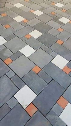 an orange and white umbrella sitting on top of a cement floor next to a sidewalk