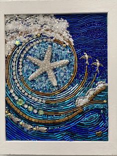 an art work made out of glass and beads with a starfish in the middle