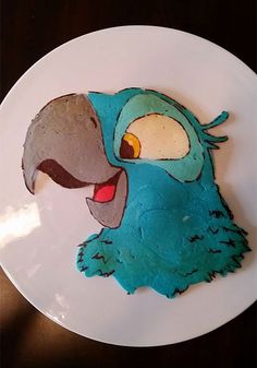 a cake shaped like an angry bird on top of a white plate with blue icing