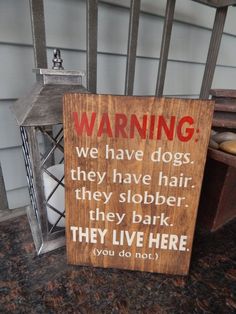 a wooden sign that says warning we have dogs, they have hair and they live here