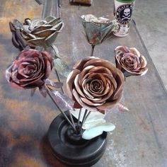 there are three roses in a vase on the table