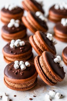 chocolate macaroons with marshmallows on top are arranged next to each other