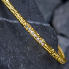 This sturdy and textured two section bangle bracelet features a fluted design and is accented with forty-two (42) prong set round brilliant cut diamonds. The bracelet measures 3.1mm wide and 3.0mm thick. The bracelet is finished with a hidden box clasp and safety chain.  It fits up to a 7 inch wrist and is crafted in 18k yellow gold. Diamond Bangle Bracelet, Diamond Bangles Bracelet, Box Clasp, Safety Chain, Diamond Bangle, Round Brilliant Cut Diamond, Round Brilliant Cut, Brilliant Cut Diamond, Estate Jewelry