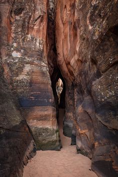 a person is standing in the middle of a narrow slot between two large rock formations