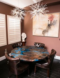 a dining room table with chairs and a chandelier hanging from the ceiling above it