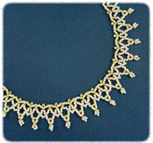 a gold necklace with white beads on it