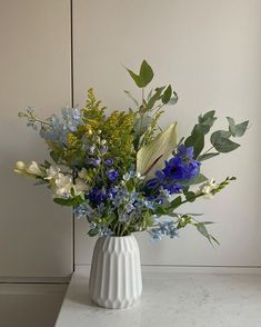 a vase filled with blue and white flowers